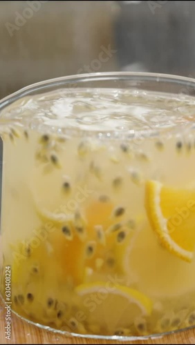 Wallpaper Mural Vertical video. In slow motion, the woman pours lemon and orange slices from the bowl into the pitcher with passion fruit juice and seeds. Torontodigital.ca