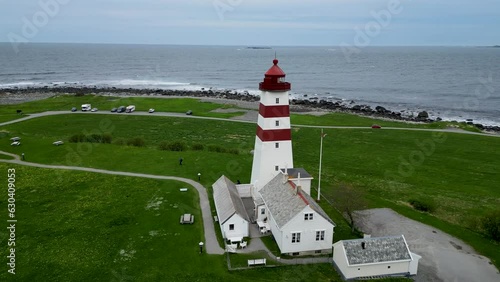 4K drone video of the wooden, white and red Alnes Fyr, light house on Godoya Island, Aalesund. photo