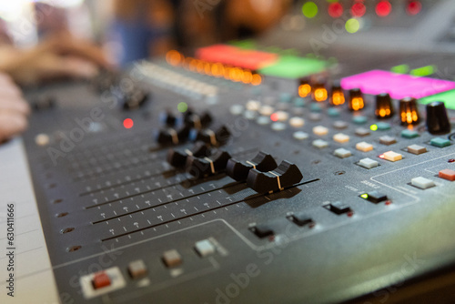 Close up of a professional musical sound mixing console. Selective focus on buttons. Blurry background. Concerts and live music