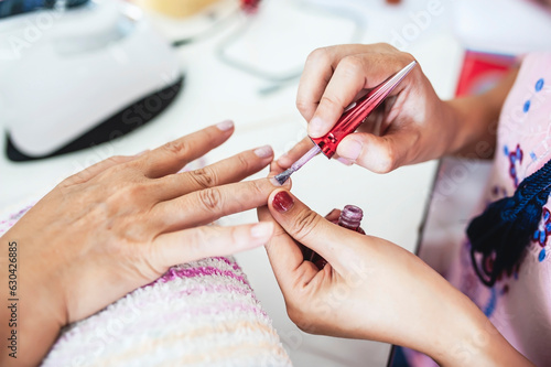 Manicurist is decorating the nails for the beauty of the hands.