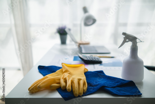blue towel and yellow gloves were placed on wooden table for cleaning staff to use to clean and prevent cleaner from dermatitis. concept of choosing cleaning company to clean the office