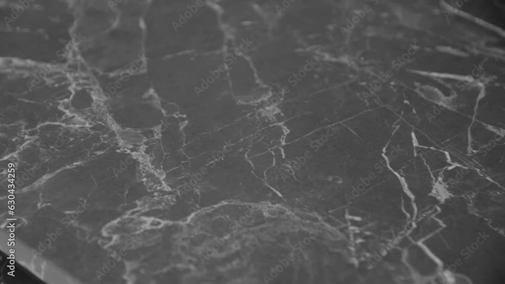 Grenight Close-up shot of beautiful granite black and grey counter top, camera ...