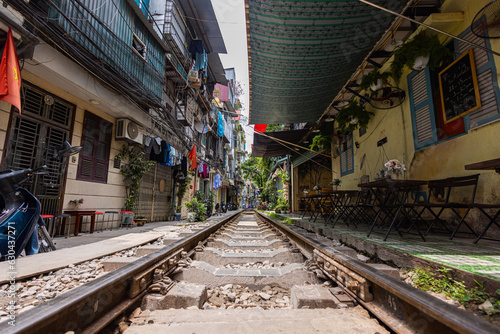 Hanoi, Vietnam - May 28, 2023: Train Street in Hanoi is a narrow, bustling lane with tracks. Close knit houses, adorned with plants, are inches away from passing trains. bars and cafes line the track