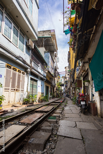 Hanoi, Vietnam - May 28, 2023: Train Street in Hanoi is a narrow, bustling lane with tracks. Close knit houses, adorned with plants, are inches away from passing trains. bars and cafes line the track