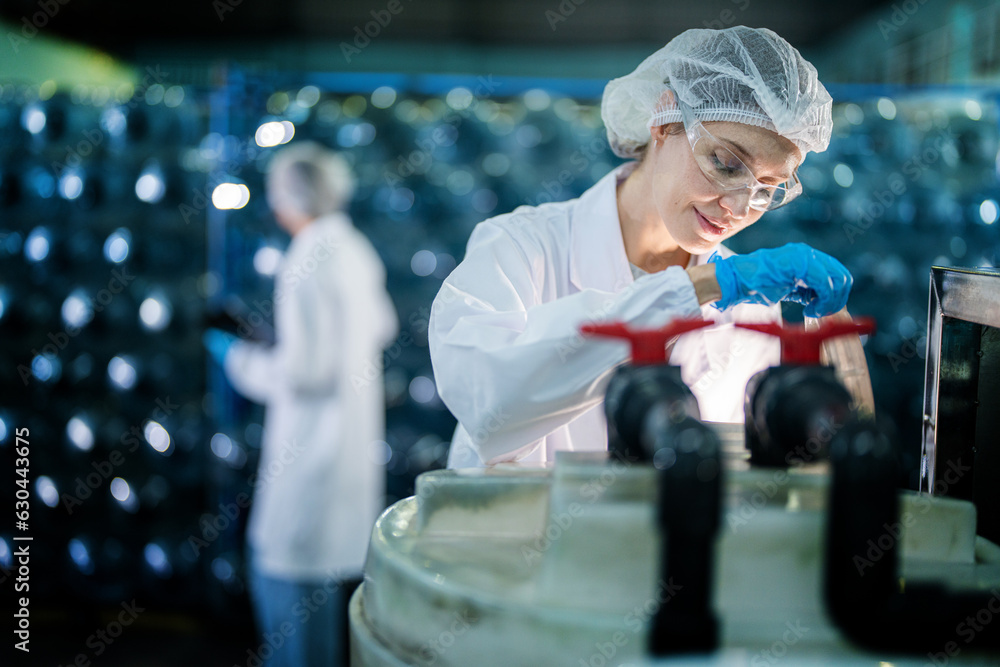 Factory worker checking water bottles in the warehouse at the ...