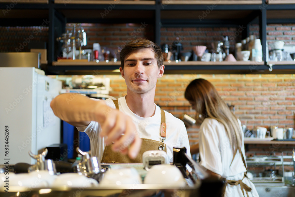 Professional caucasian coffee barista making a cup of coffee by using a modern espresso machine. Barista serving a cup of coffee to female customer over the coffee bar. Professional caucasian coffee barista making a cup of coffee by using a modern espresso machine. Barista serving a cup of coffee to female customer over the coffee bar.