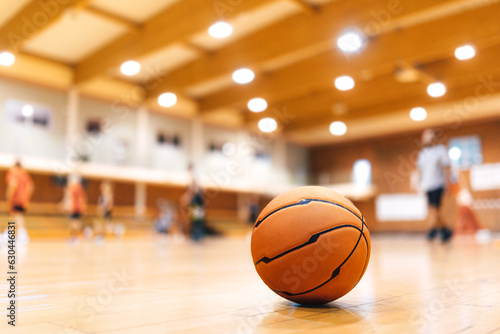 Basketball Ball on Wooden Court. Basketball Game in the Blurred Background. Basketball Court Background. Classic SPorts Basketball Ball © matimix
