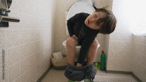 One cute little boy sitting on toilet seat. child doing his hygiene needs