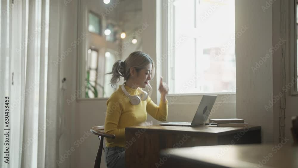 Happy excited asian woman winner watching laptop Happy excited asian woman winner watching laptop