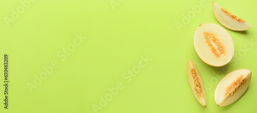 Pieces of sweet melon on green background with space for text, top view
