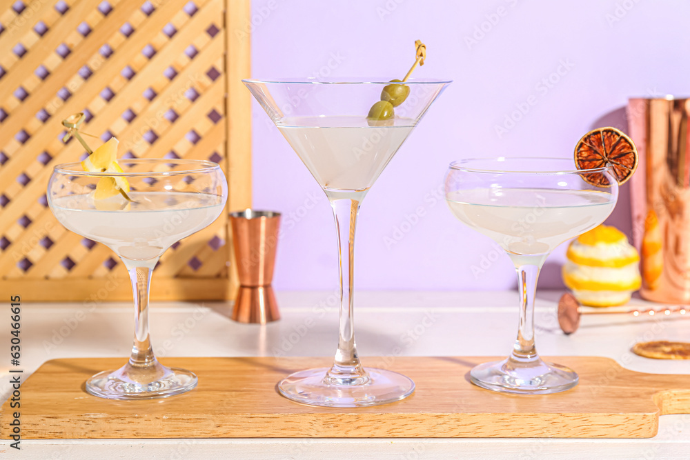 Board with glasses of martini on table