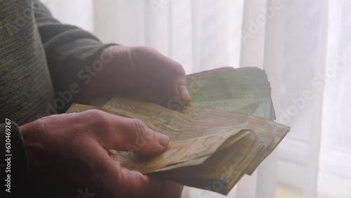 man holding, counts lot of national currency of Sri Lanka, paper money bills Rupee banknotes, devaluation, high inflation of state, exchange rate on travel, vacation, savings, banking, tax payment photo