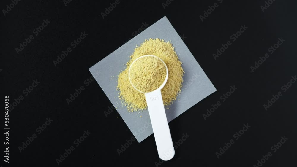 Measuring spoon with Crushed fenugreek seeds or Hulbah powder, top view. 4K video, Rotating