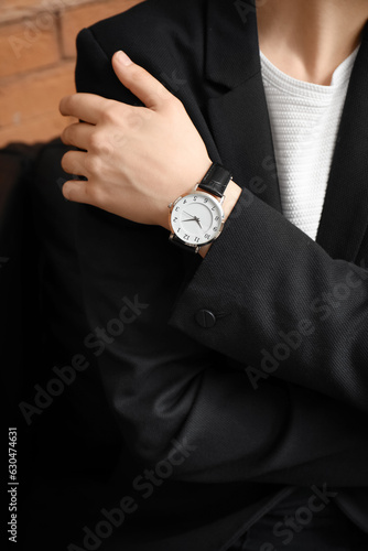 Young woman with wristwatch in room, closeup