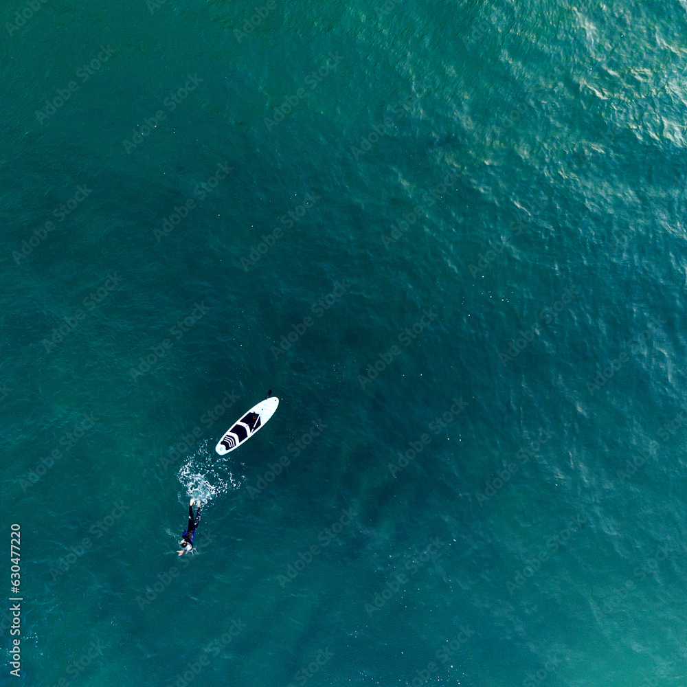 Imagen aérea de un nadador y tabla de surf en el mar de Rosarito