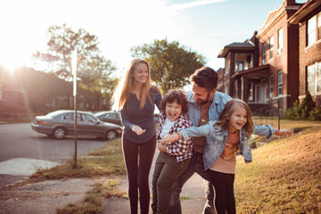 Young family walking on a sidewalk in a neighborhood of a city