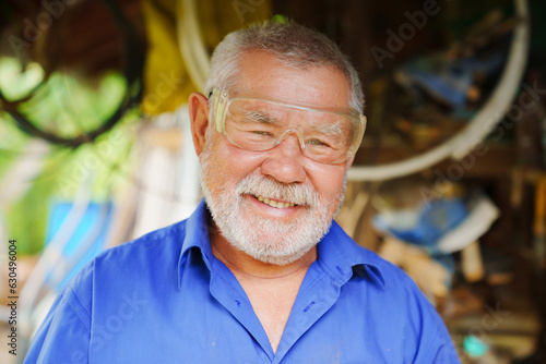an elderly man in goggles to work with a circular saw