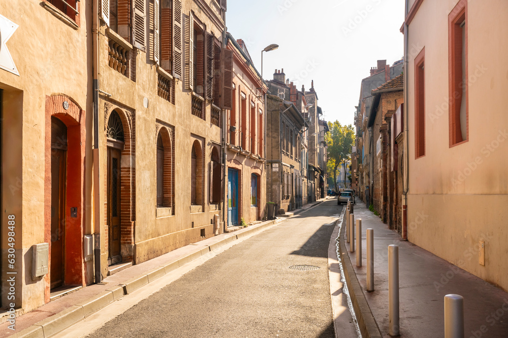 Fototapeta premium Facade or exterior of historic traditional houses in red or orange in the old city of Toulouse, France