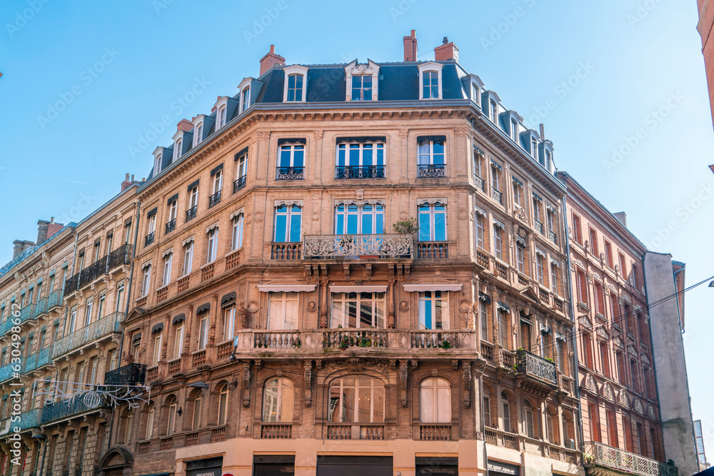 Facade or exterior of historic traditional houses in red or orange in the old city of Toulouse, France Facade or exterior of historic traditional houses in red or orange in the old city of Toulouse, France