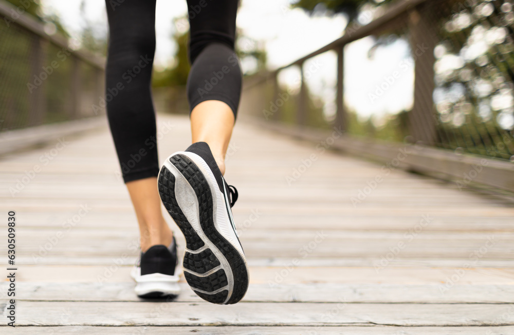 Young woman running over wooden bridge in sports clothing and footwear. Young woman running over wooden bridge in sports clothing and footwear.