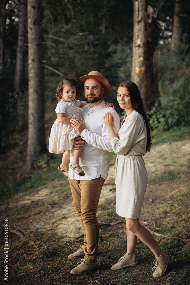 Happy family with little daughter in the forest Happy family with little daughter in the forest