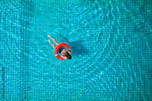 Billede på lærred Lifeguard girl training with a life preserver swimming in the pool