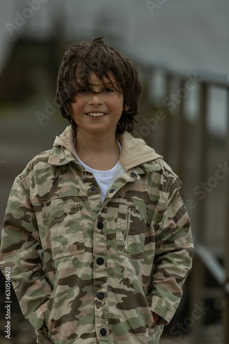 teenage  boy in a military style jacket background blur