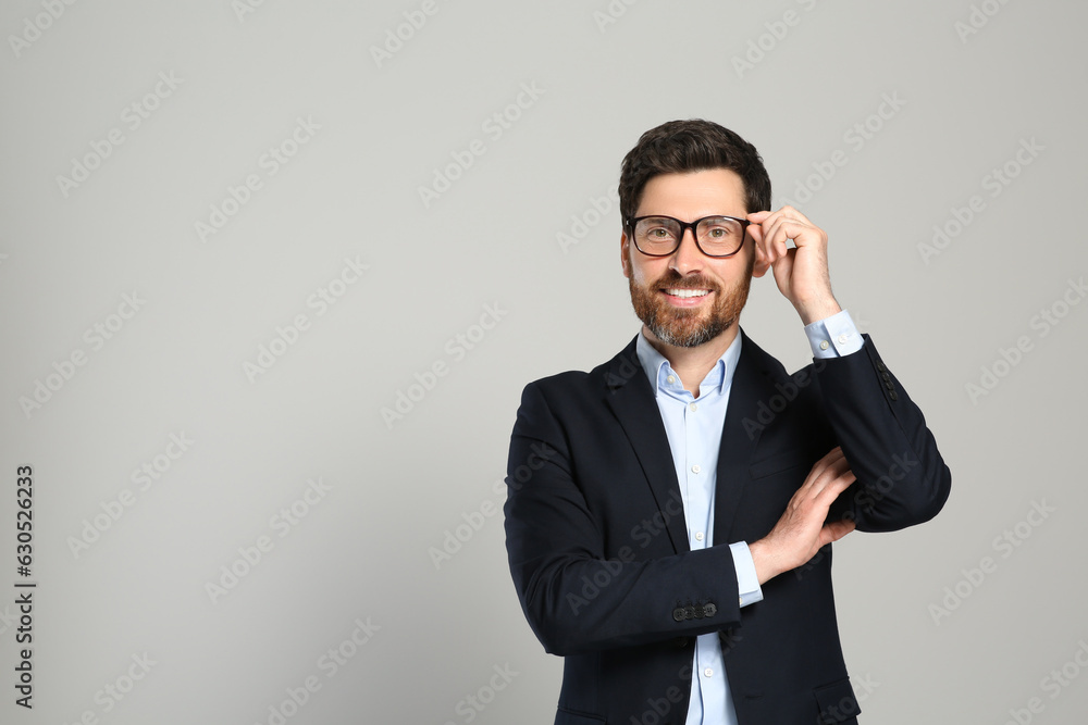 Handsome real estate agent in nice suit on grey background, space for text Handsome real estate agent in nice suit on grey background, space for text