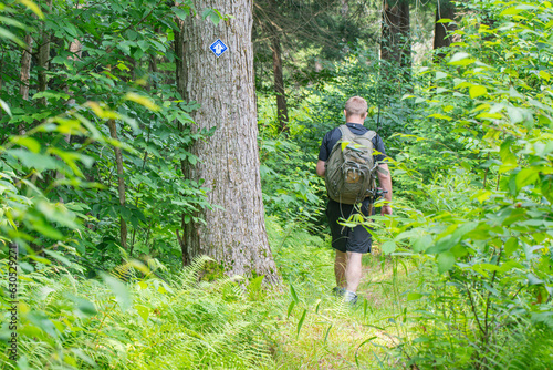 Hiker with a backpack hiking the trail in the woods 