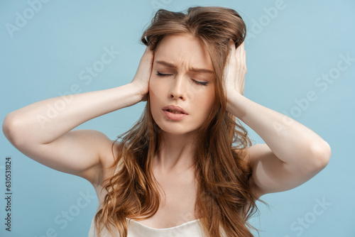 Fotografie Closeup, tired woman with long hair with headache holding her head isolated on b