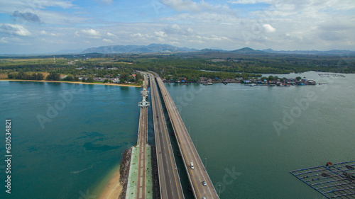 .Aerial view beautiful Sarasin bridge on the blue sea..Sarasin bridge is important route connecting by land..Scene of white cloud in blue sky and green sea..the bridge connect Phuket to Phang Nga..