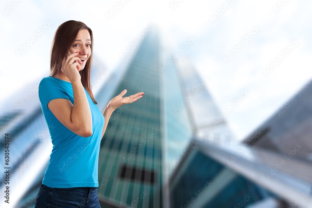 Young cheerful successful businesswoman talking on the phone.