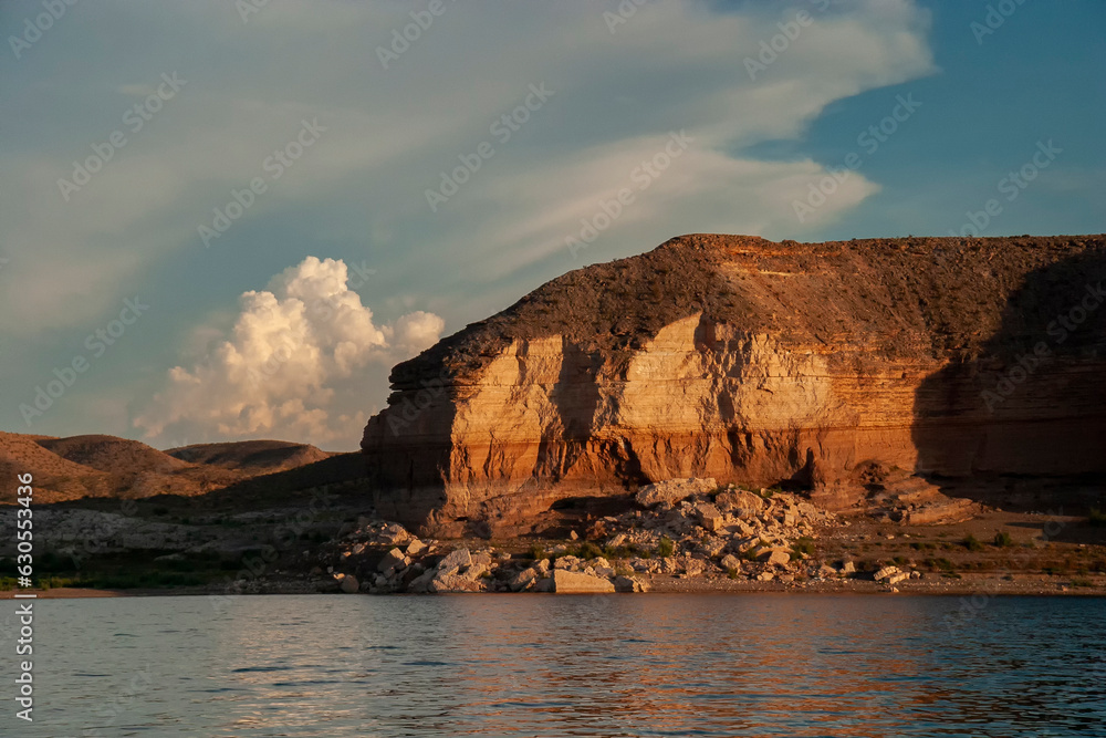 Dramatic desert rock formation rising above a lake with cloud and sky background  at Lake Mead Nevada