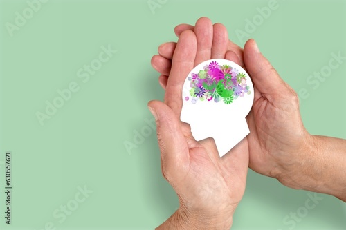 Hands holding human head model with brain
