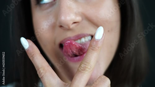 V Sign With Tongue Out Between Fingers, Close Up, Woman Signifying Cunnilingus in Front of Camera photo