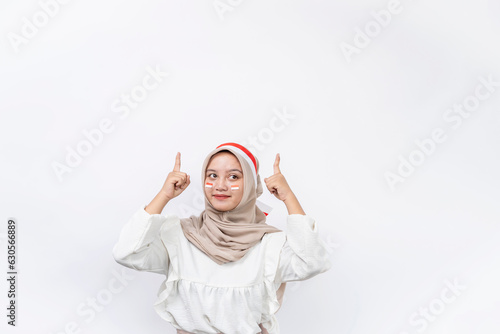 Happy young Asian muslim woman celebrate Indonesian independence day showing thumb up gesture isolated on white background. Indonesian independence day concept photo