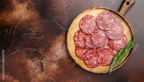 Meat food sausage salami slices on cutting board on aged brown background, mockup. Copy space, flat lay top view photo