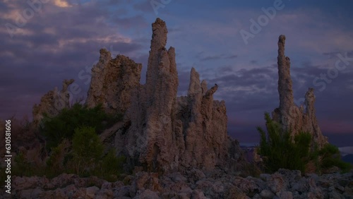 Tufa rock formations near shore of Mono Lake in Eastern Sierra area of California at sunrise with purple sky and clouds