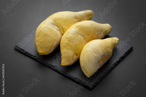 yellow Lava Durian Sisaket flesh on black slate and dark tone texture background, king of fruit, one of the most expensive fruit