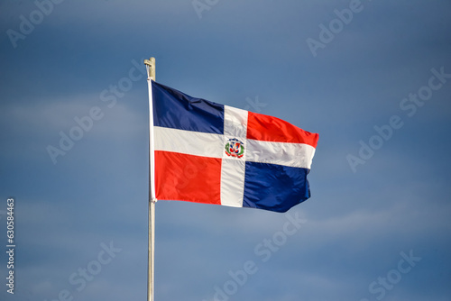 bandera de republica dominicana ondeando sobre el cielo azul