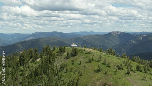 Aerial above white fire lookout tower on mountain peak in northern Idaho in summer photo