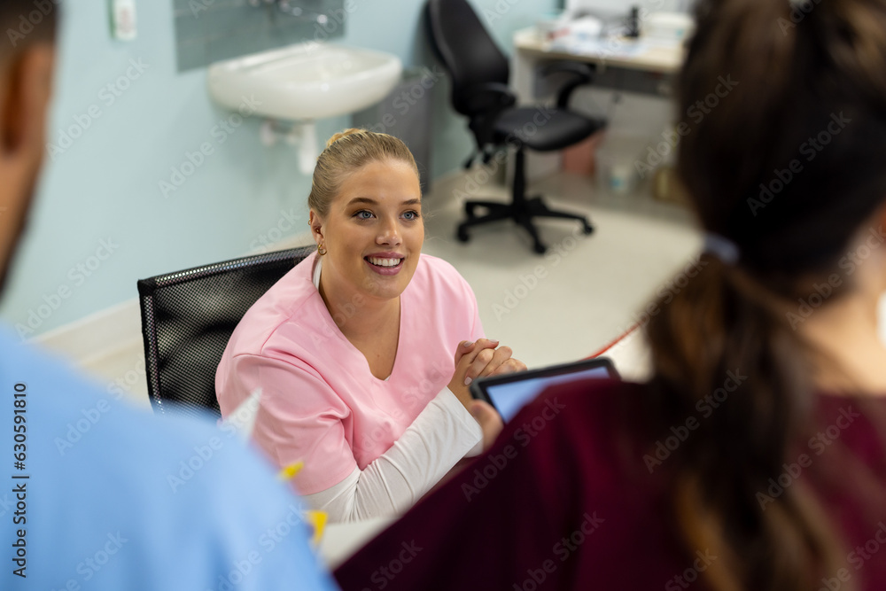 Diverse doctors talking at reception desk at hospital Diverse doctors talking at reception desk at hospital