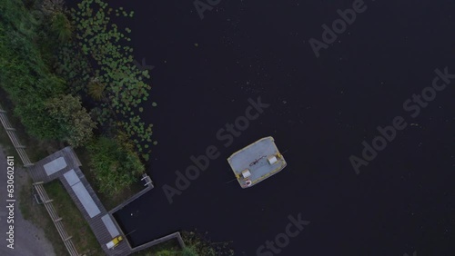 Young woman is driving the bicycle ferry (Fietspont de Deelen) during sunset, aerial photo