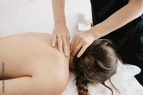 Masseur doing a foot massage with candles on background
