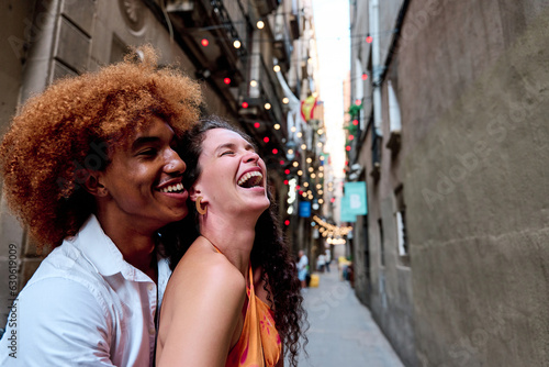 Canvas Print multiethnic couple of tourists laughing in Gothic Quarter, Barcelona, Spain