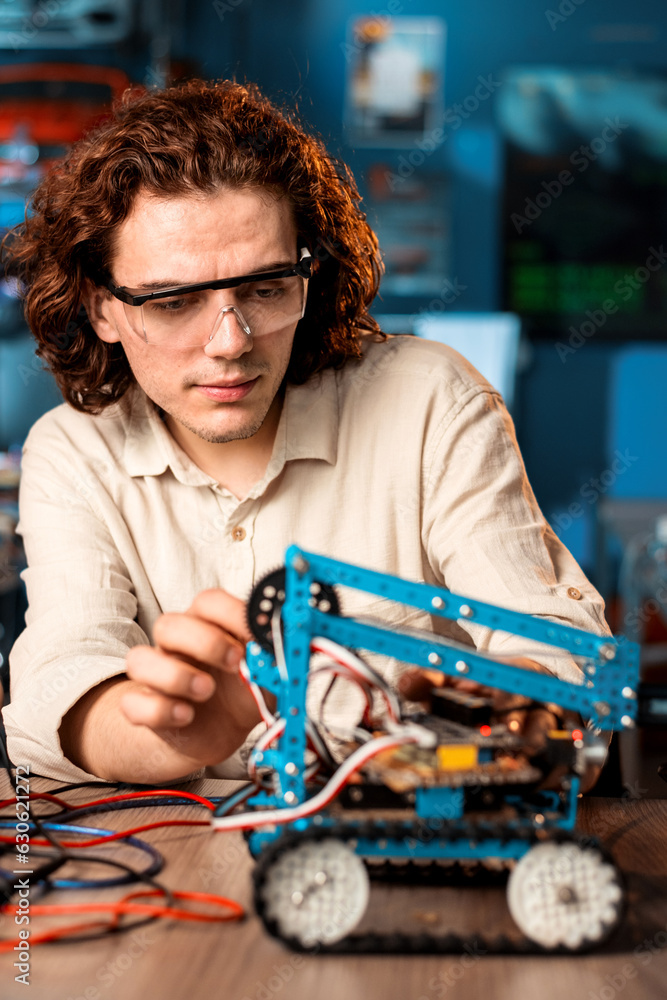 Young man doing experiments in robotics in a laboratory