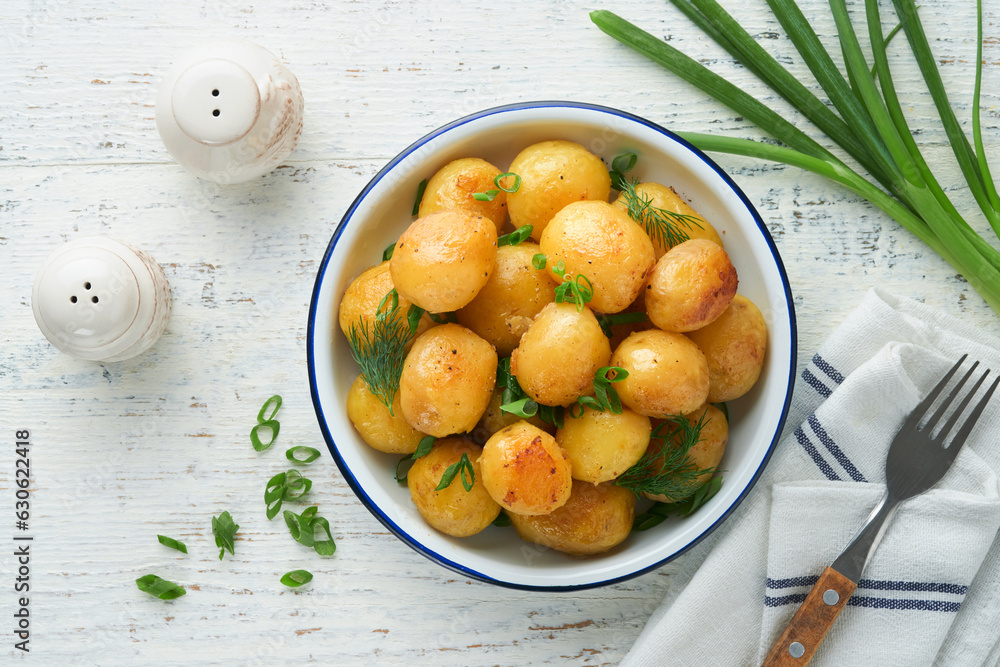 Boiled new or young potatoes with butter, fresh dill and onions in white bowl on white old rustic wooden background. Tasty new boiled potatoes. Top view. Boiled new or young potatoes with butter, fresh dill and onions in white bowl on white old rustic wooden background. Tasty new boiled potatoes. Top view.