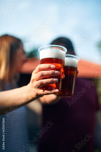 People holding beer cups and enjoying summertime outdoors.