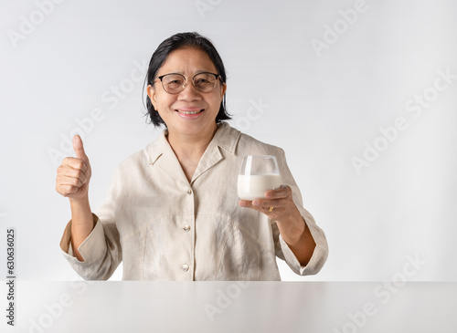 Asian senior woman drinking milk happily