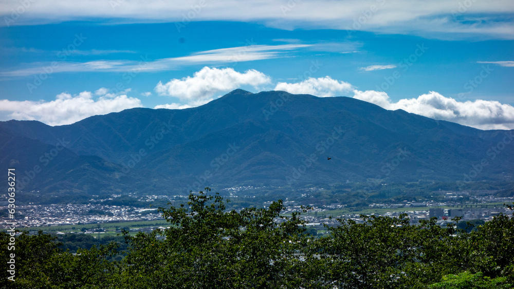 夏に鞍手町の剣岳山頂から蒼くかすむ福智山を望む